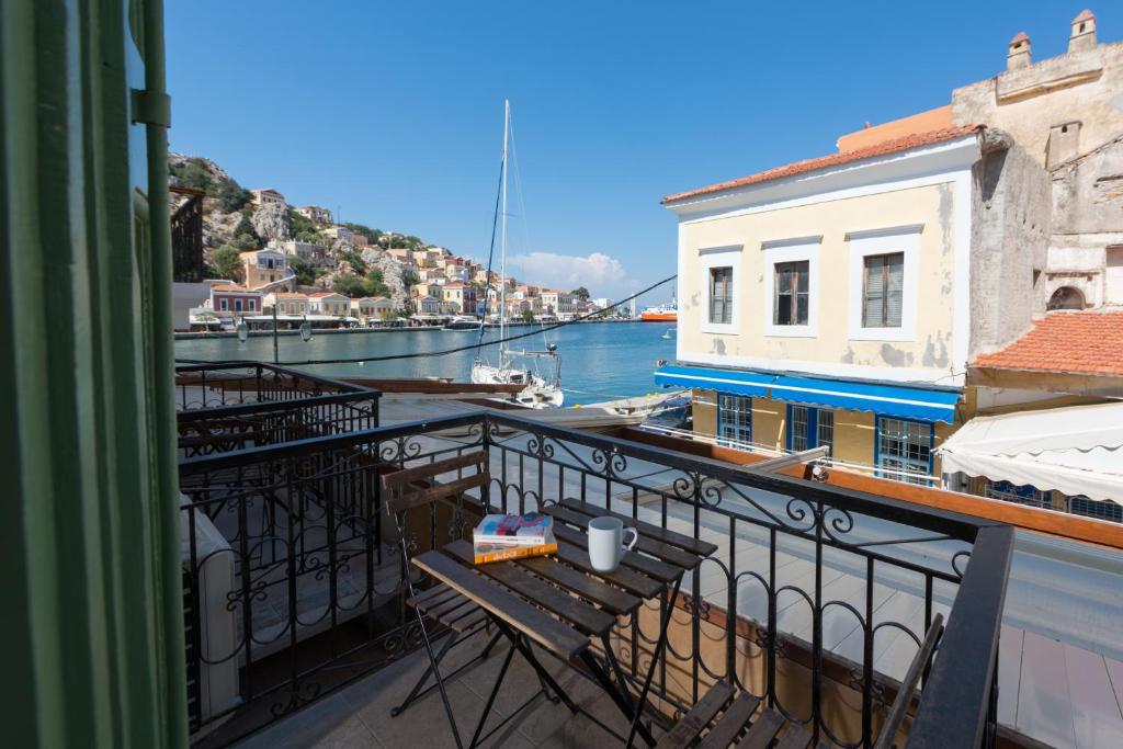 a balcony with a table and a view of the water at Elena in Symi