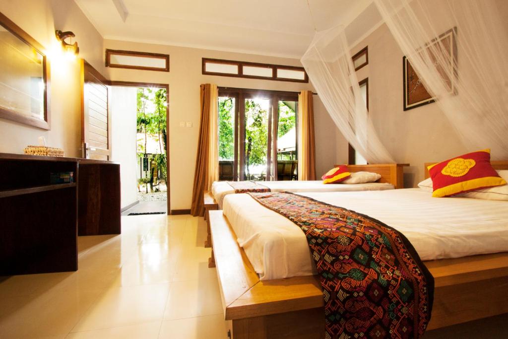 a bedroom with two beds and a large window at Waiwo Dive Resort Raja Ampat in Rabia
