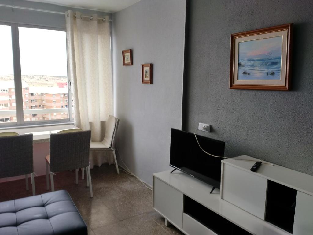 salon z telewizorem, kanapą i oknem w obiekcie Apartment Grand Via w Alicante