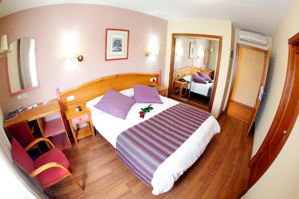 a hotel room with a large bed and a mirror at Maria de Luna in Segorbe