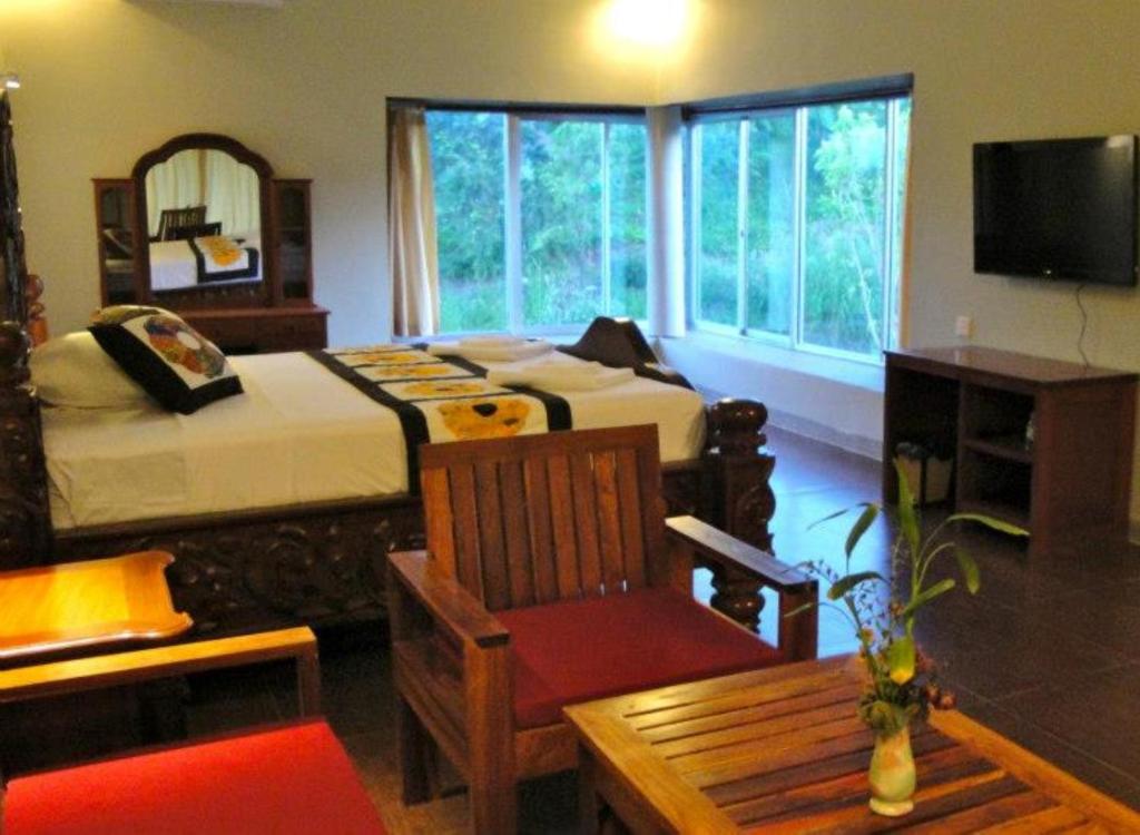 a bedroom with two beds and a table and a chair at Memoria Palace & Resort in Pailin