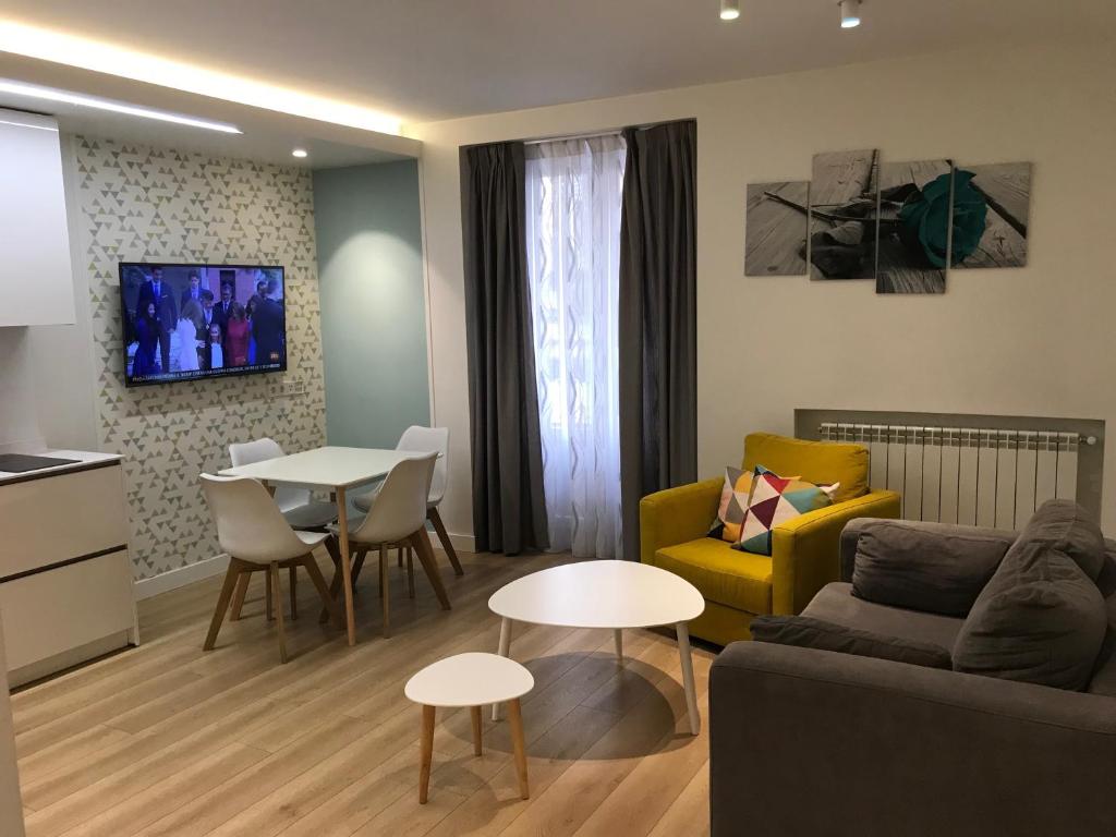 ein Wohnzimmer mit einem Sofa und einem Tisch in der Unterkunft Apartamentos Apolo in Madrid