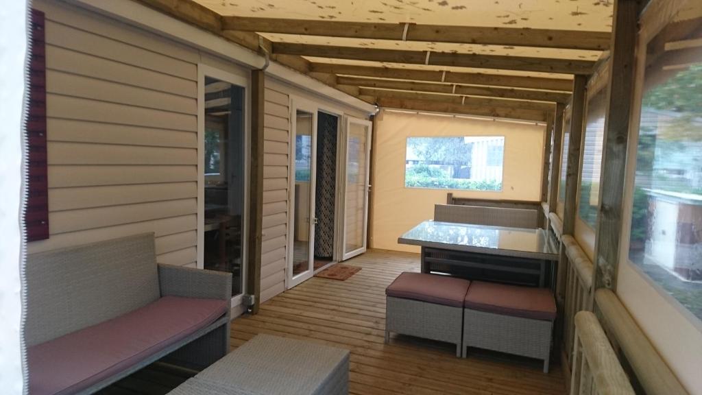 ポン・タヴェンにあるMobile Home dans Domaine de Kerlannのベンチ2台と窓が備わる小さな客室です。