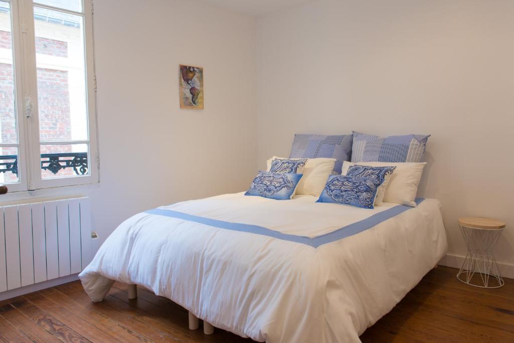 トゥルヴィル・シュル・メールにあるVilla Panamaのベッドルーム1室(青と白の枕が備わるベッド1台付)