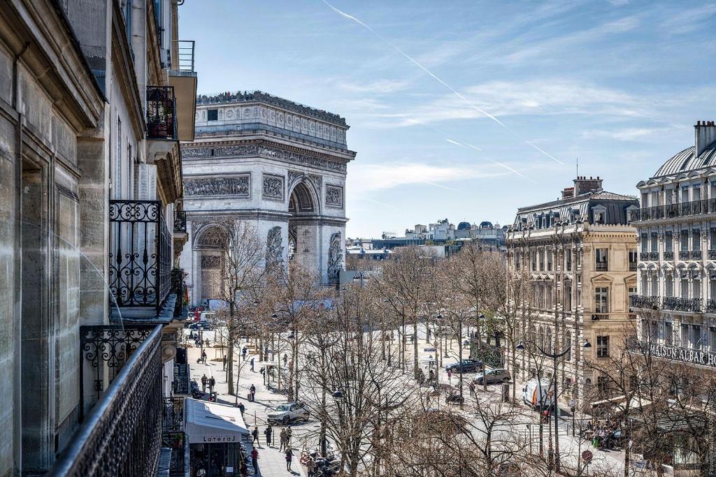 einen Balkon mit Blick auf eine Stadt mit Gebäuden in der Unterkunft Etoile Park Hotel in Paris