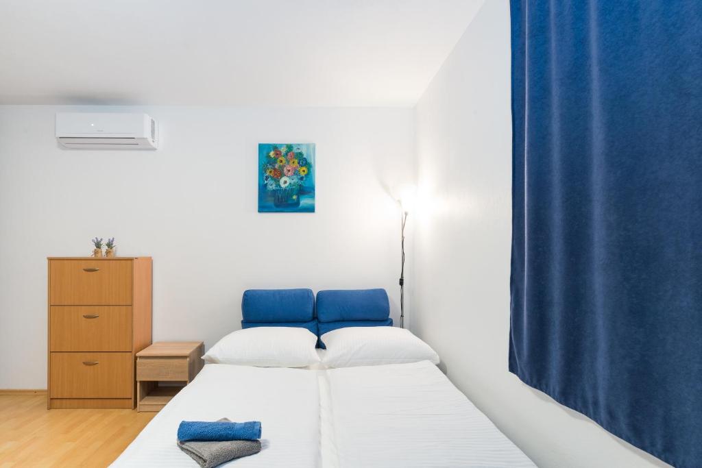 um quarto com duas camas e uma cortina azul em Sun studio apartman em Zadar
