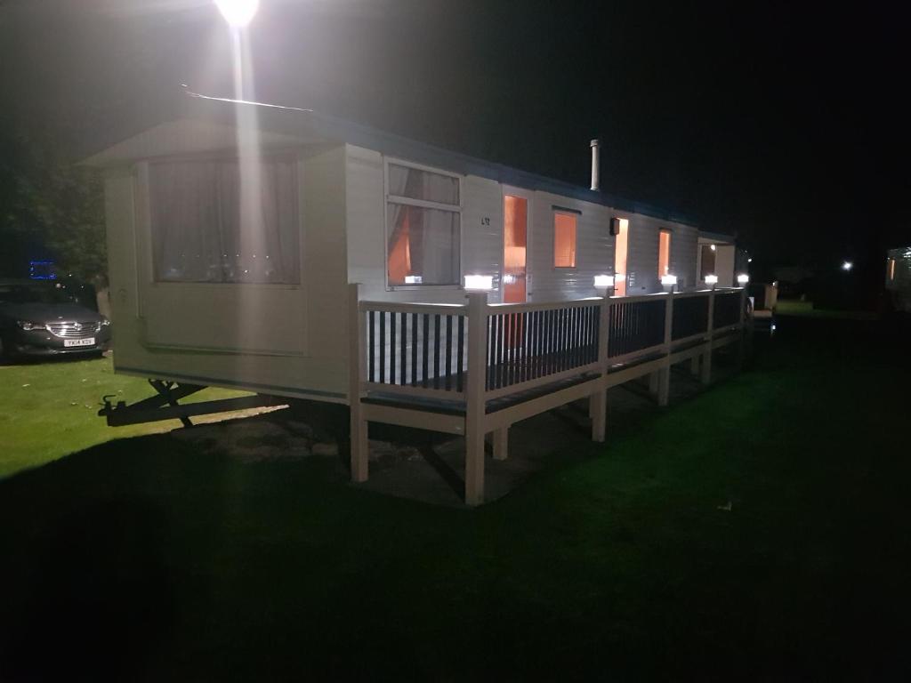 a house with a porch at night with a street light at Mablethorpe L12 Caravan in Mablethorpe
