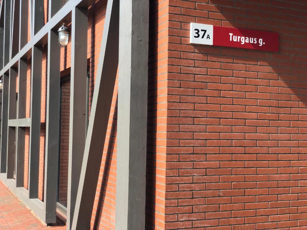 a brick wall with a street sign on it at Memel home old city apartment in Klaipėda