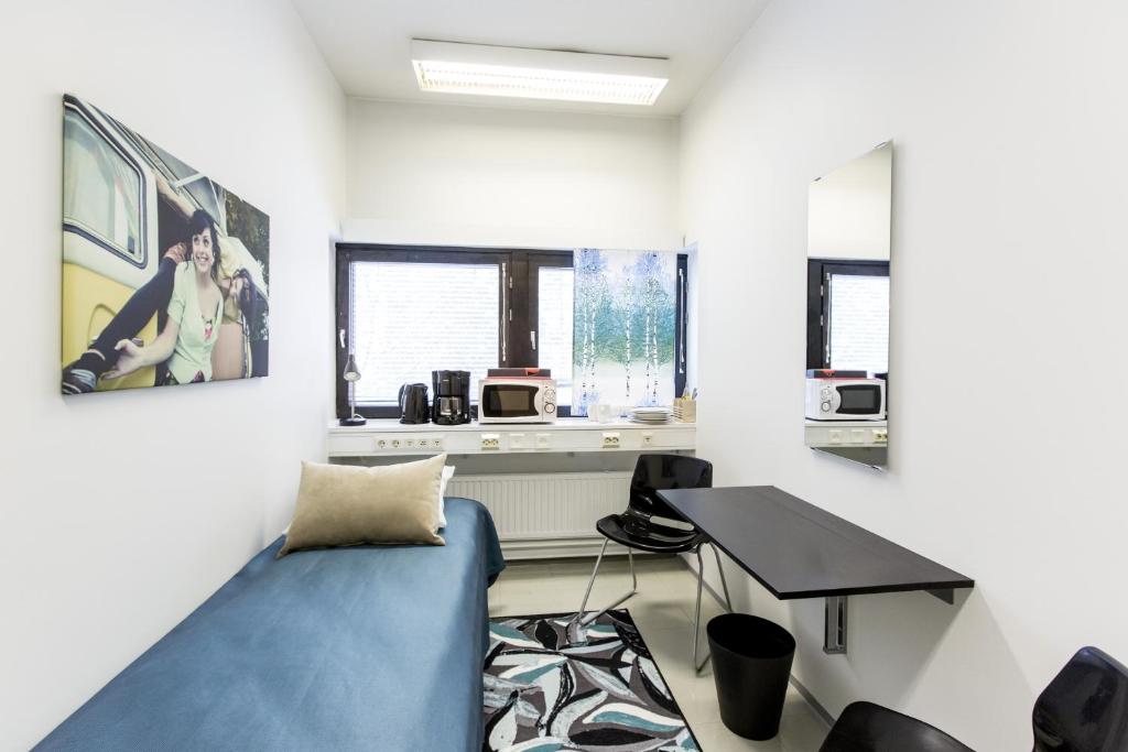 a living room with a blue couch and a table at Forenom Hostel Vantaa Airport in Vantaa