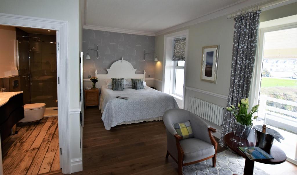 a bedroom with a bed and a chair at Watersmeet Hotel in Woolacombe