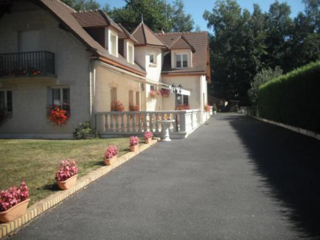 a house with potted plants on the side of the road at Les chambres du lac in Forges-les-Eaux