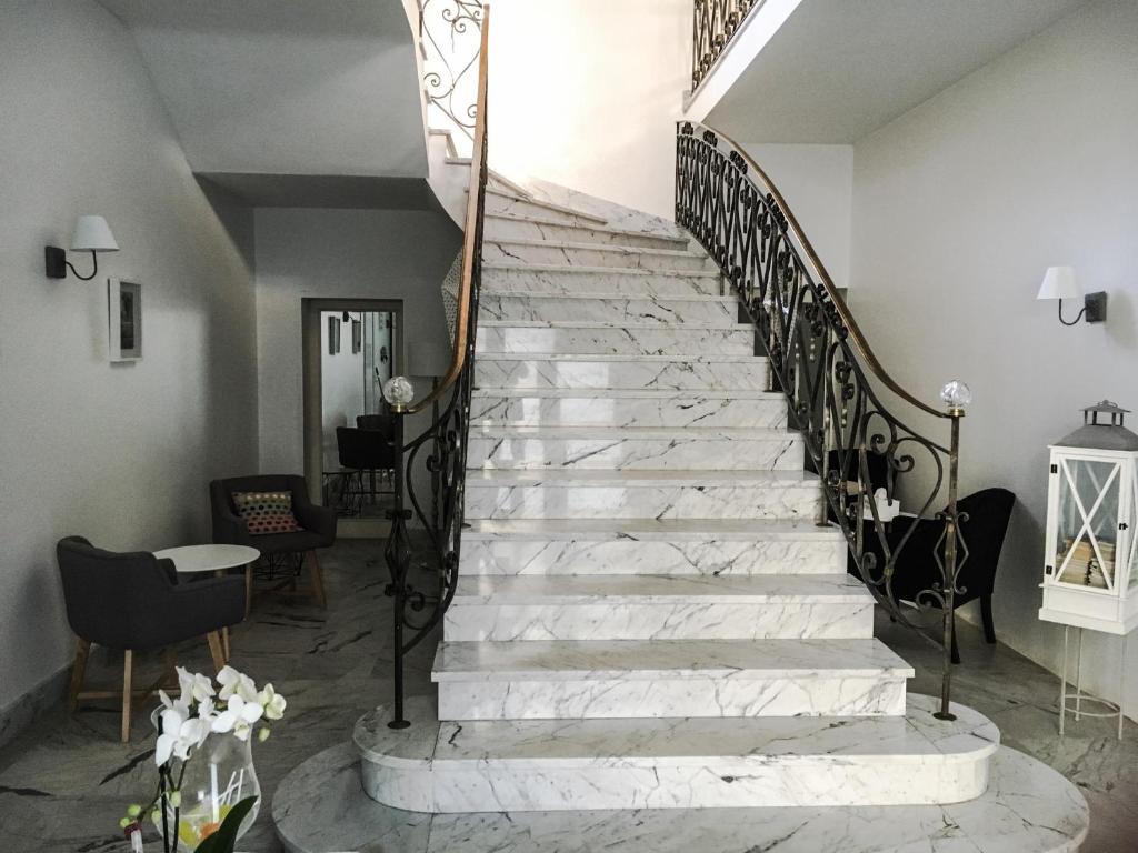 klatka schodowa w domu z białym marmurem i czarnymi poręczami w obiekcie La Demeure d'Alexandra w mieście Cholet