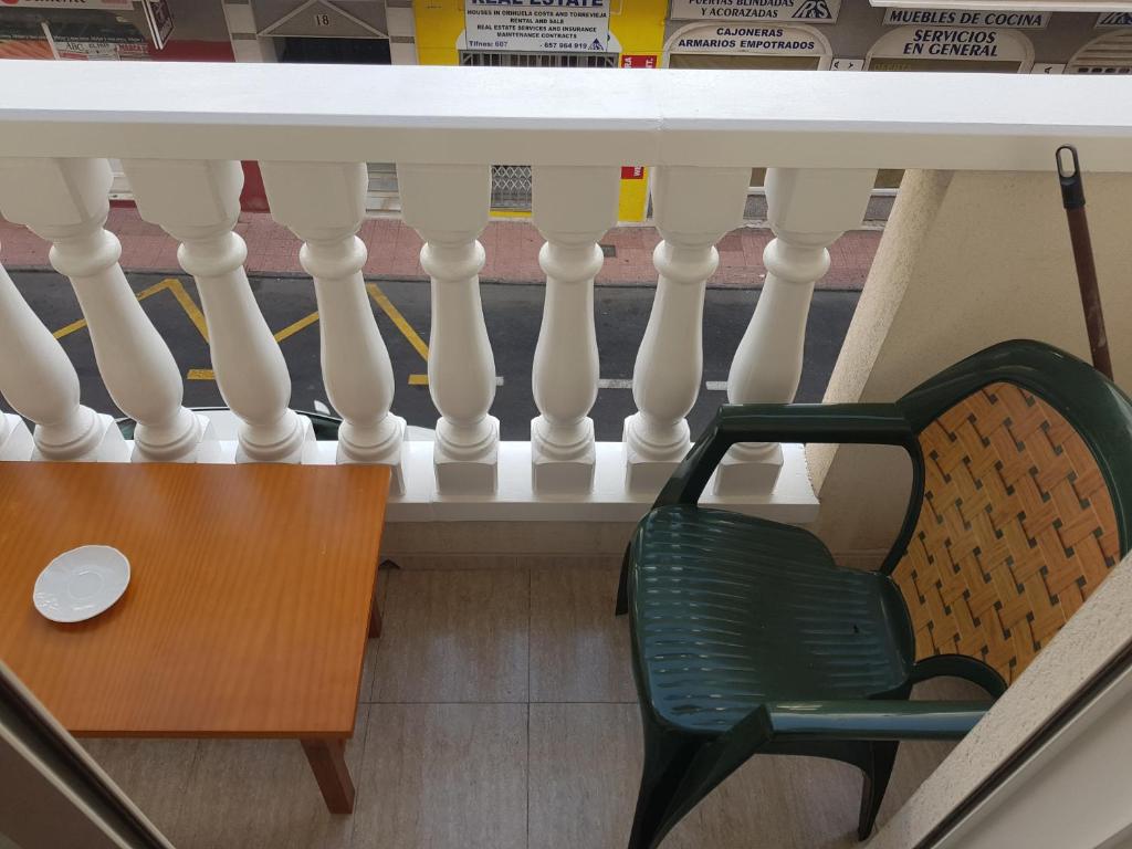 una silla verde sentada en un balcón en SAL -Estudio a 200m de la playa del Cura en Torrevieja