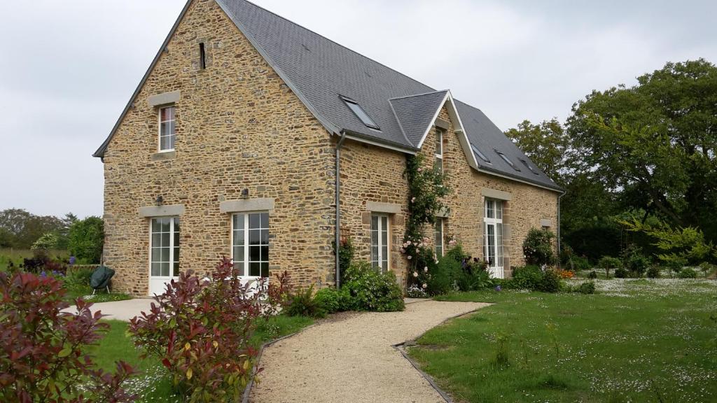 a large brick building with a black roof at Maison Leonard in Vains