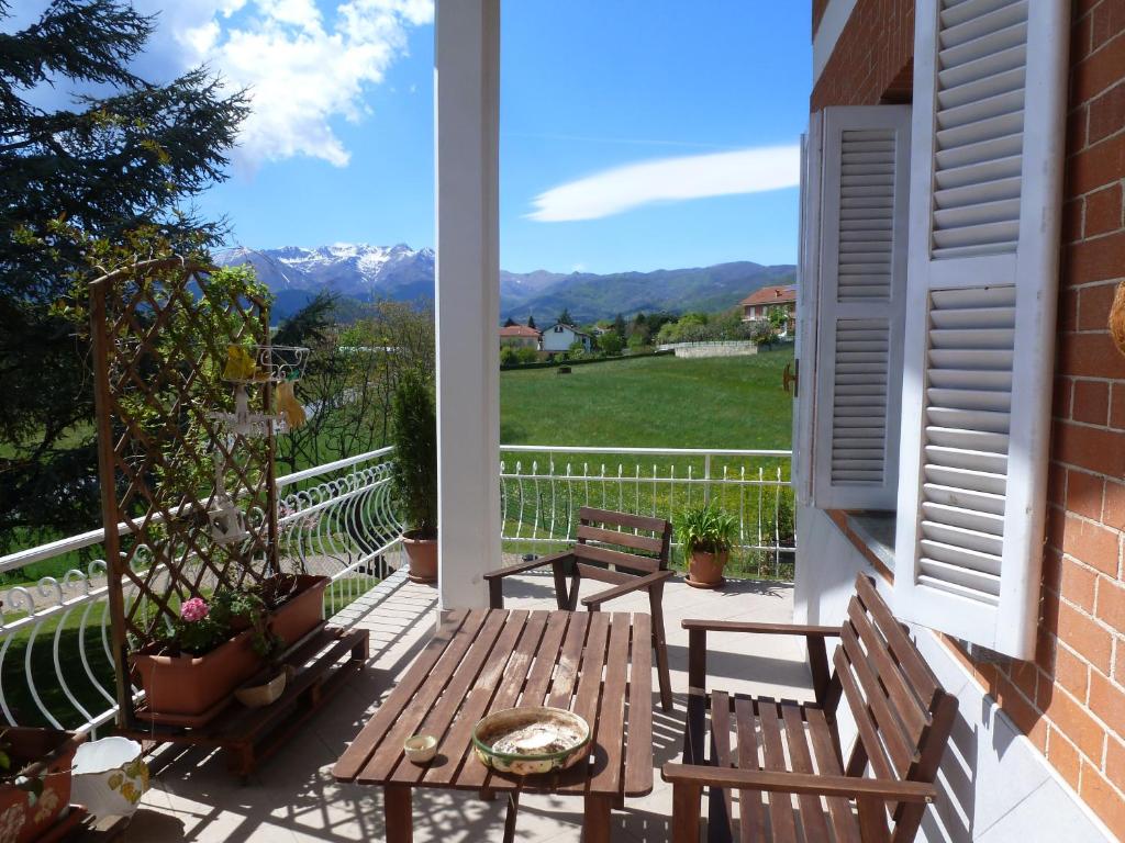 un porche con 2 bancos y una mesa con vistas en B&B Tre Confini, en Giaveno