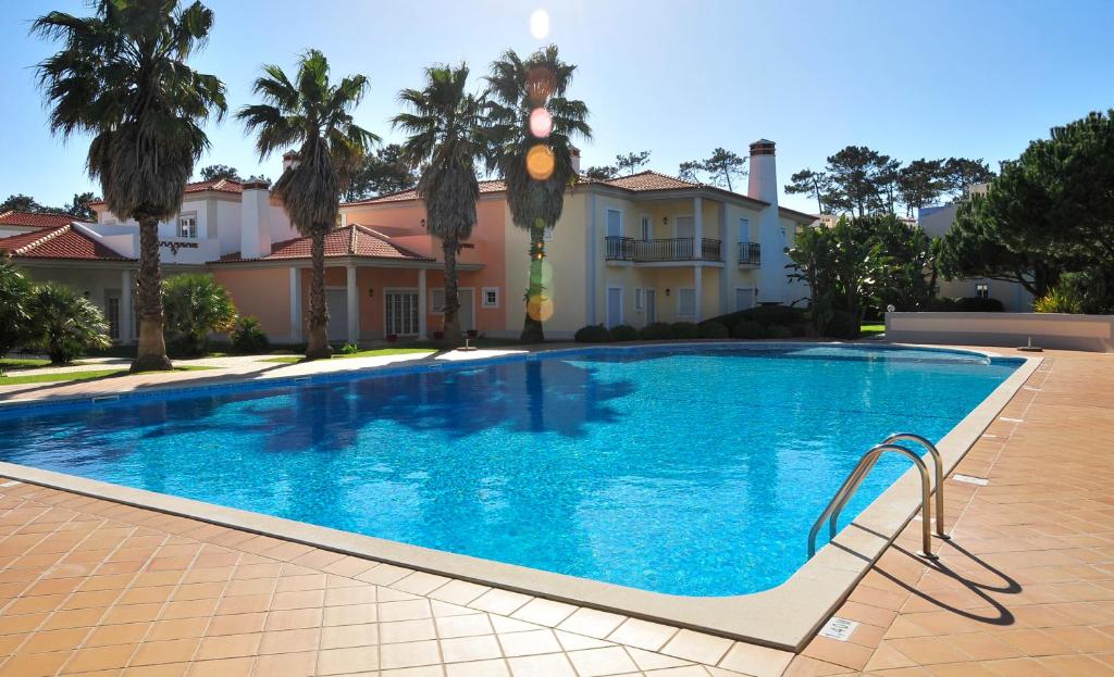 a large swimming pool in front of a house at Praia Del Rey Beach Three Pools in Amoreira