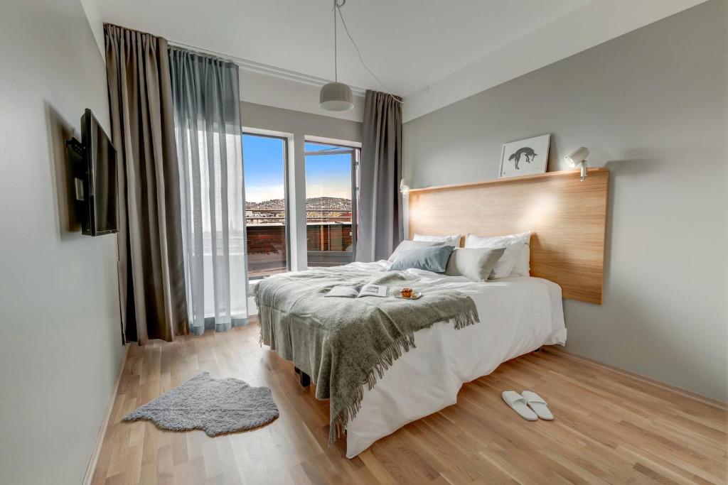 a bedroom with a large bed and a large window at Forenom Aparthotel Oslo in Oslo