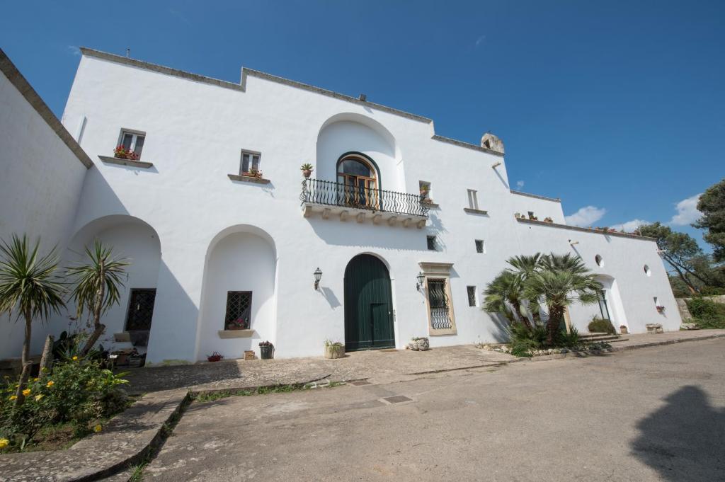 un gran edificio blanco con una puerta verde en La Foresteria dell'Astore, en Cutrofiano