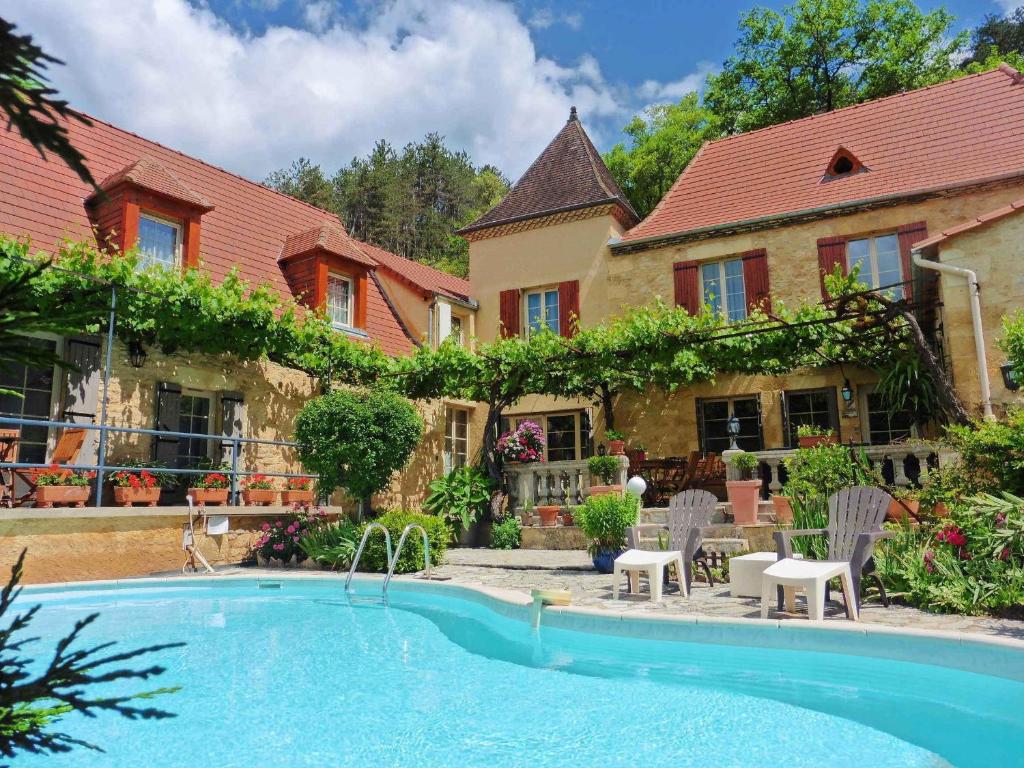 una casa con piscina delante de una casa en La Belle Demeure proche Sarlat, en Saint-Cybranet