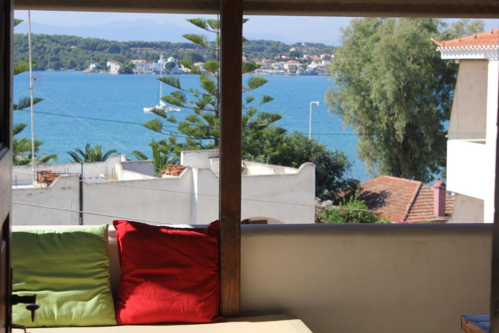 a couch sitting in front of a window with a view of the water at Alice House in Porto Heli