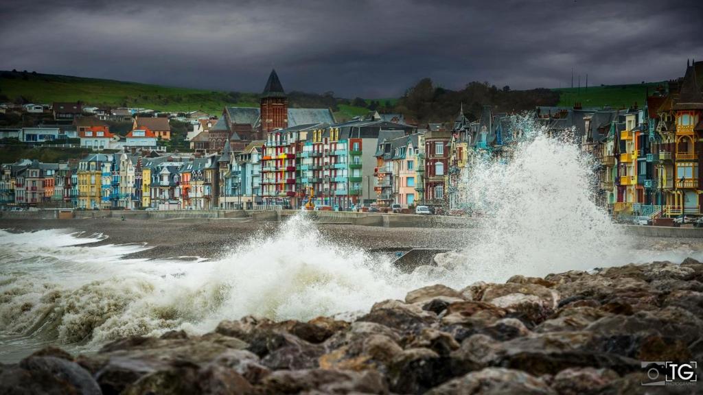 un groupe de bâtiments et de vagues sur une plage dans l'établissement La Falaise, à Mers-les-Bains