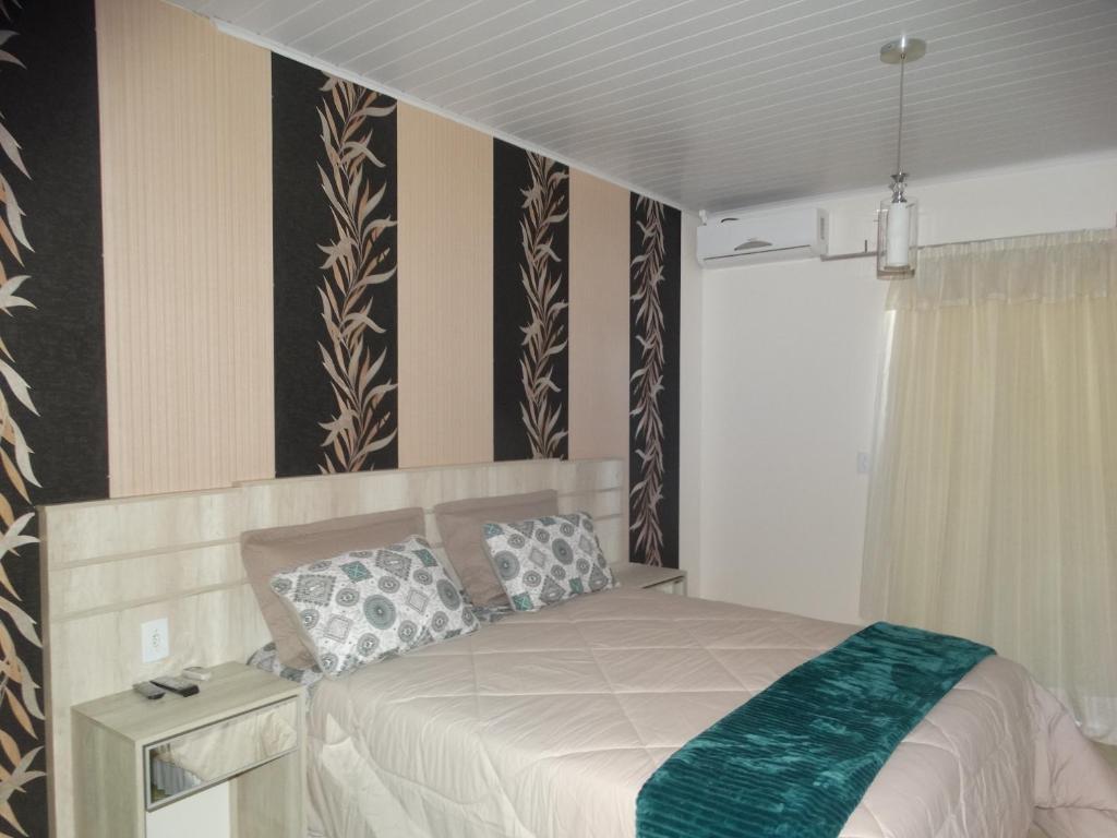 烏魯比西的住宿－Pousada Central，一间卧室配有一张带绿毯的床