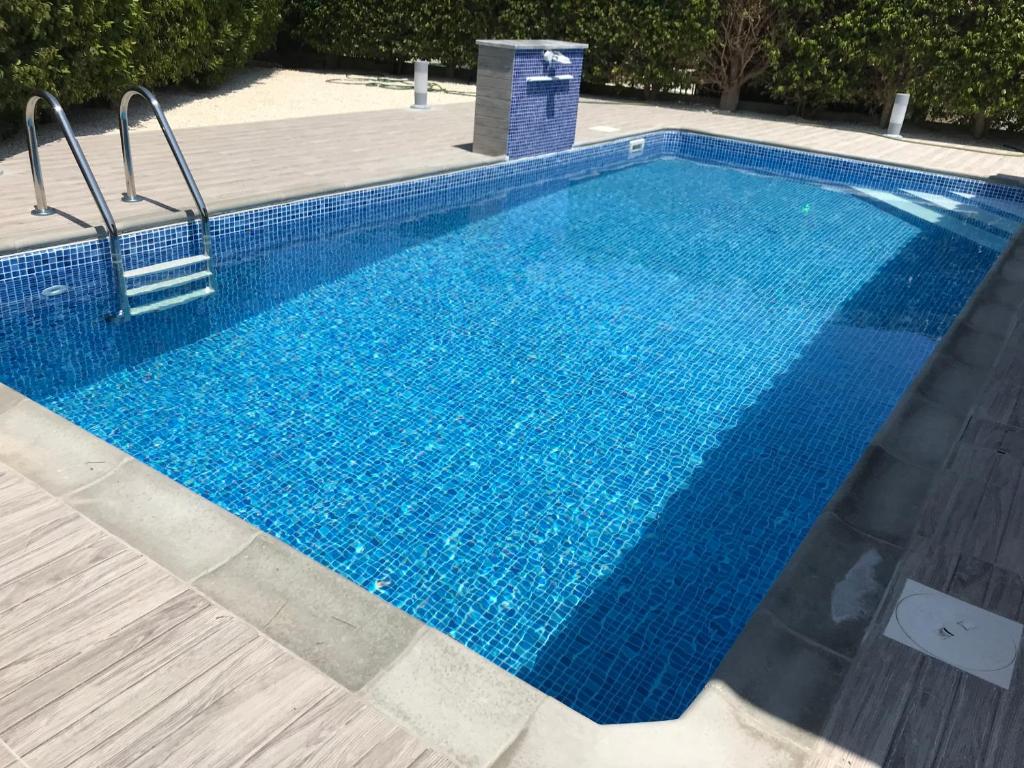 een groot zwembad met blauw water bij Giorgio Vacation House in Pissouri