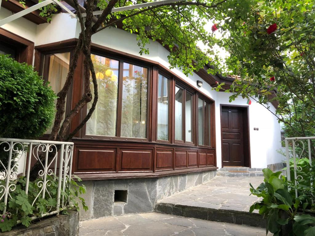 uma casa com uma grande porta de madeira e uma árvore em The House With The Piano em Plovdiv