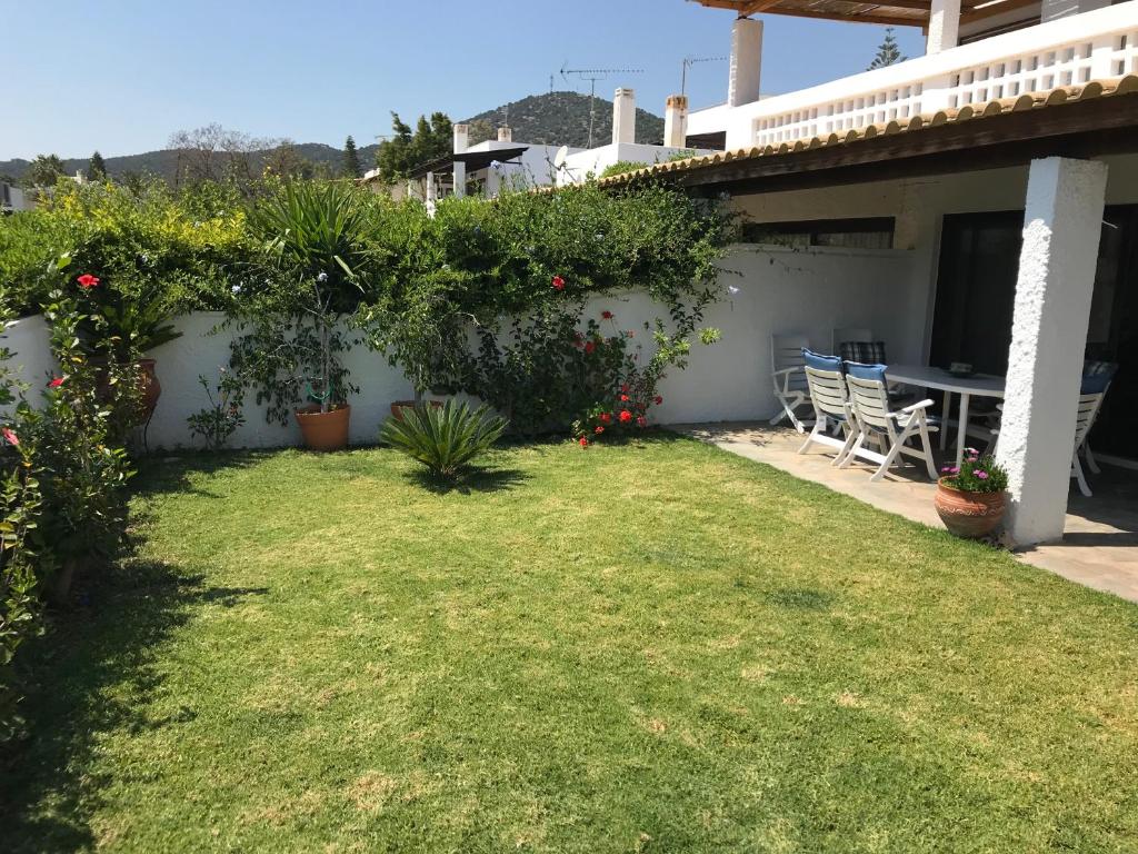 a backyard with a table and chairs and plants at Porto Hydra in Ermioni