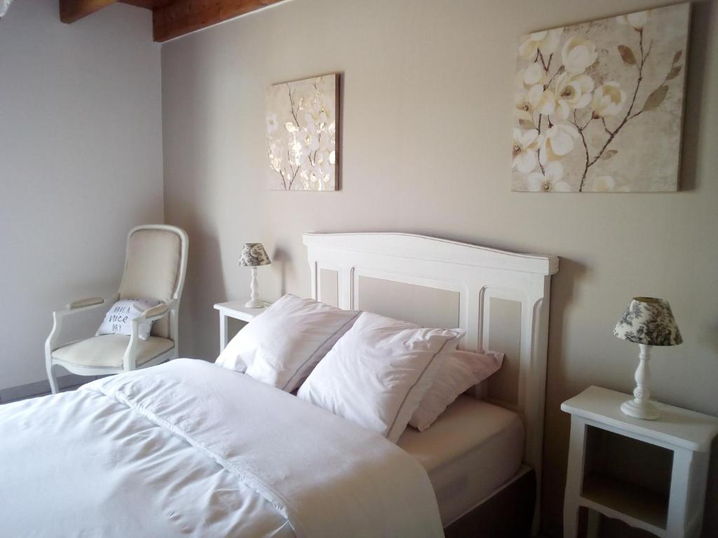 1 dormitorio con 1 cama blanca y 2 sillas en La Hulotte au Col Haut, en Audrehem