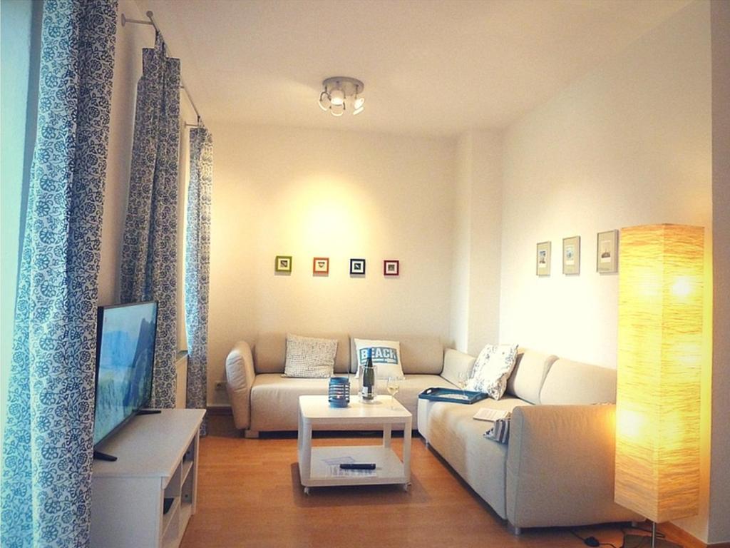 ein Wohnzimmer mit einem Sofa und einem TV in der Unterkunft Ferienwohnung Strandläufer in Kühlungsborn