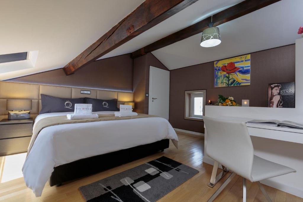 a bedroom with a large bed and a desk at The Queen Luxury Apartments - Villa Gemma in Luxembourg