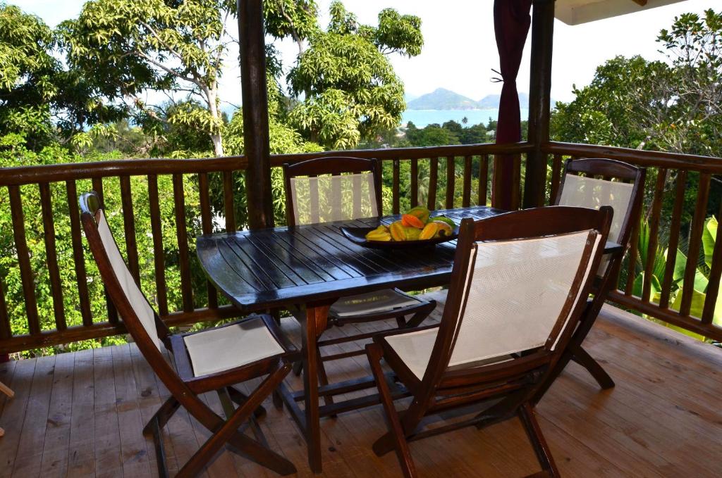 un tavolo nero e sedie su una terrazza con un cesto di frutta di Kaz Ladouceur a La Digue