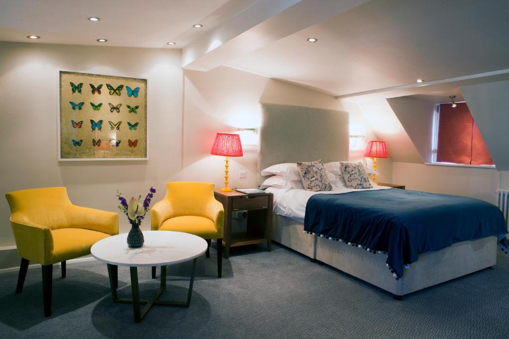 a bedroom with a bed and two chairs and a table at Sea Spray Hotel in Brighton & Hove