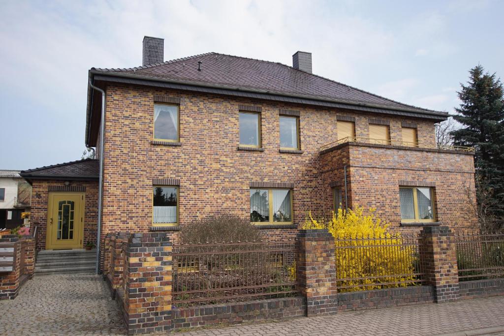 a brick house with a fence in front of it at Ferienhaus Halbritter Krina in Krina