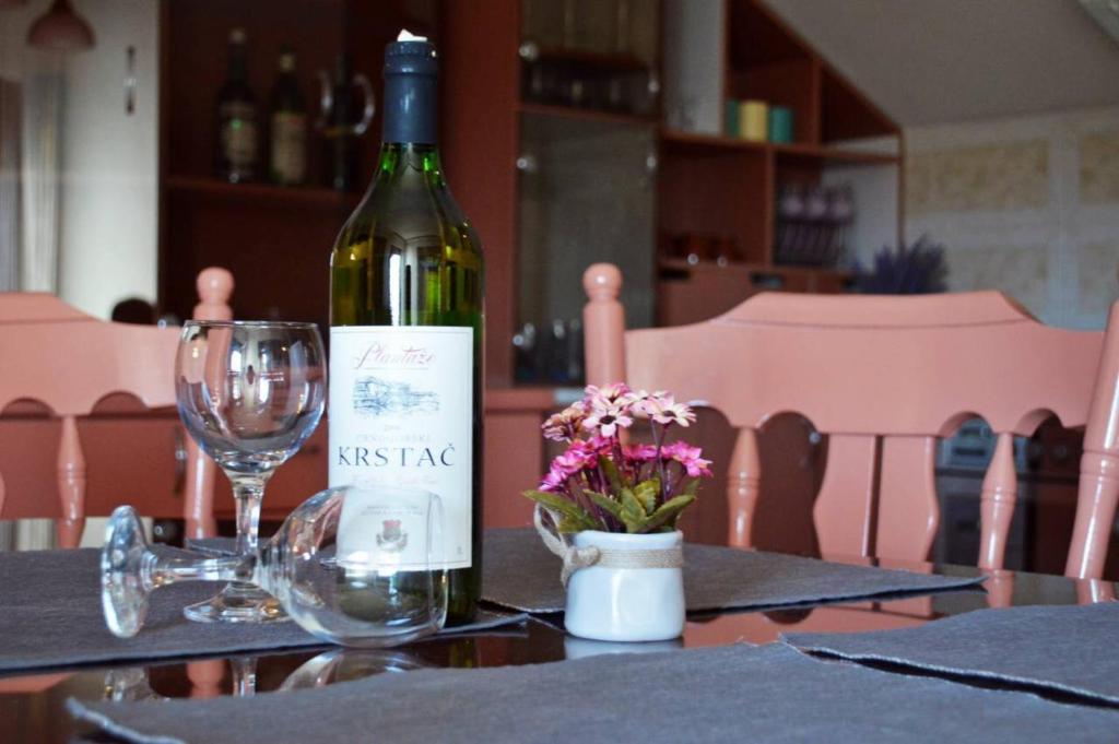 una botella de vino sentada en una mesa con una copa en Apartman EXCLUZIV, en Prijedor