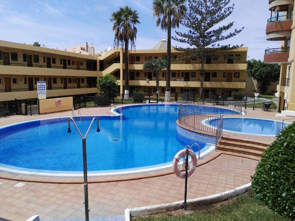 a large swimming pool in front of a building at TORRES DEL SOL A 50 metros playa las vistas in Playa de las Americas