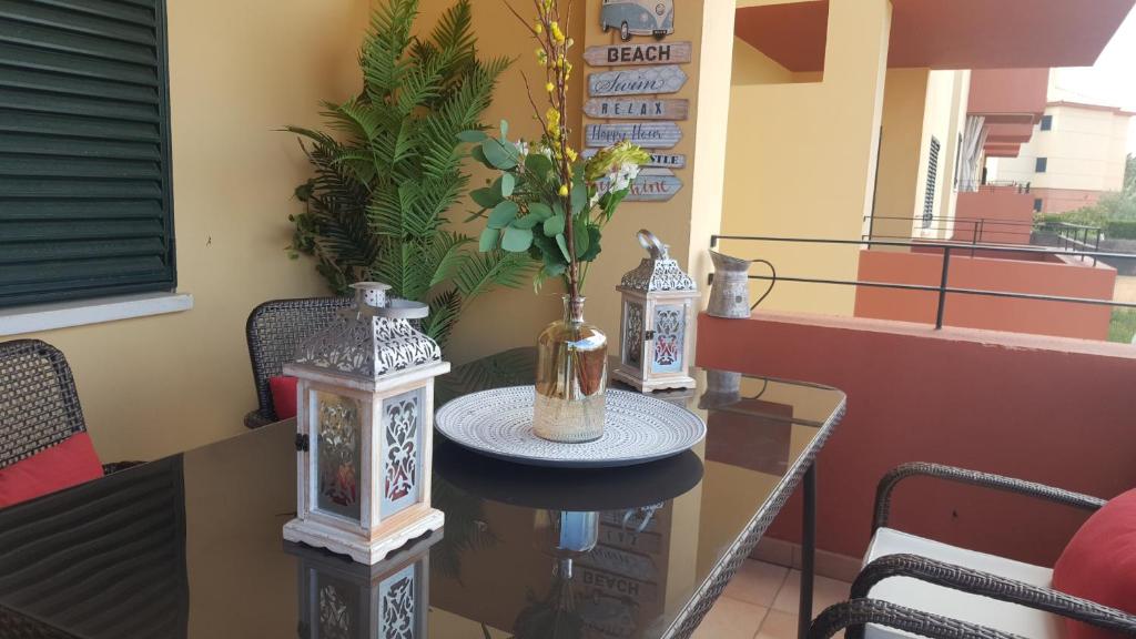GLC Islantilla في هويلفا: طاولة مع إناء من الزهور على شرفة
