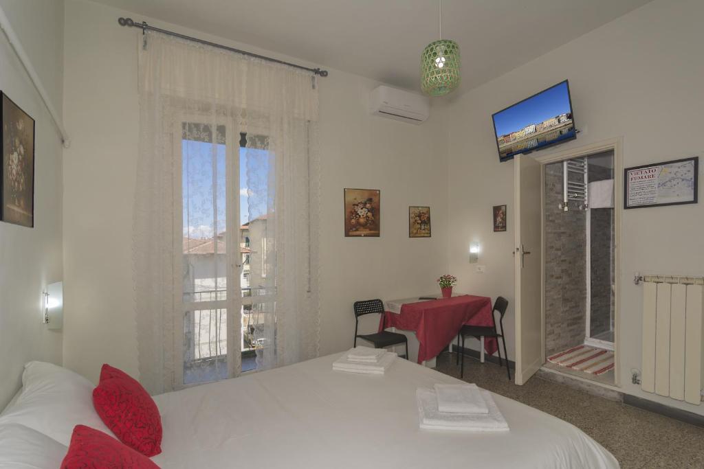 um quarto com 2 camas, uma mesa e uma televisão em Aliante B&B em Pisa