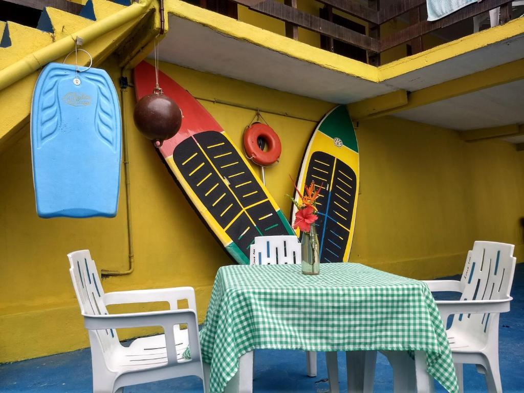 a table and chairs in a room with surfboards at Pousada Popeye in Praia de Araçatiba