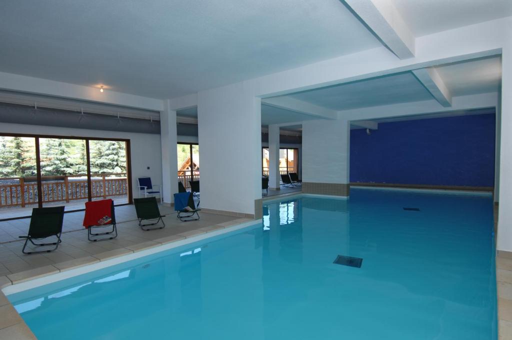 una gran piscina con sillas en un edificio en Résidence Odalys Pra Sainte Marie, en Vars