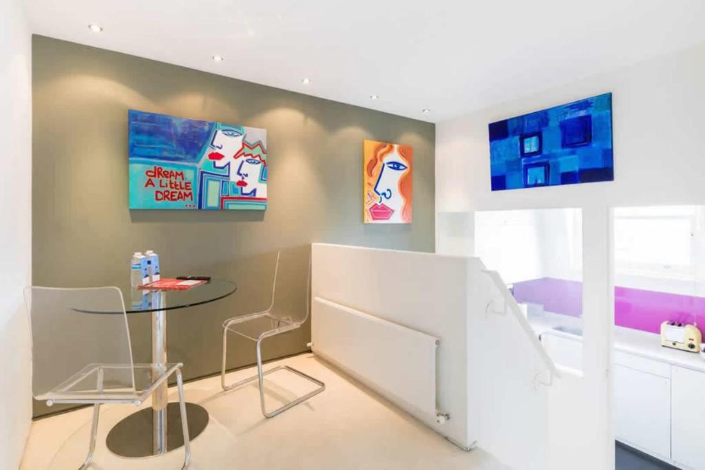 una stanza con un tavolo e alcune immagini sul muro di Comfortable Aircon Apartment Earls Court a Londra