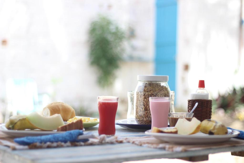 a table topped with plates of food and drinks at Pousada Infinito Azul in Prea