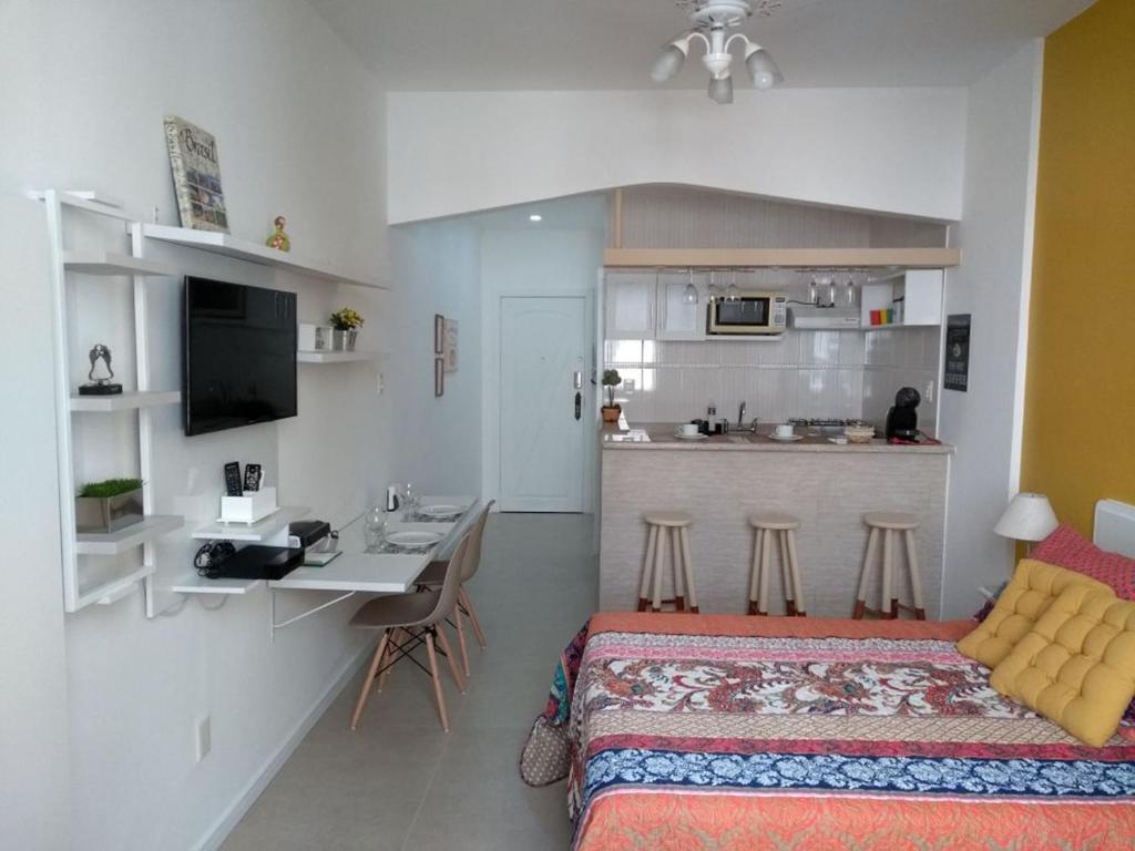 a bedroom with a bed and a desk and a kitchen at Nice Studio in Copacabana in Rio de Janeiro