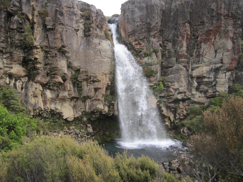 a waterfall on the side of a rocky mountain at Alexander Motel in Taumarunui