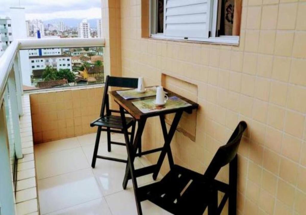 un tavolino e 2 sedie sul balcone di APARTAMENTO - GUILHERMINA - PRAIA GRANDE a Praia Grande