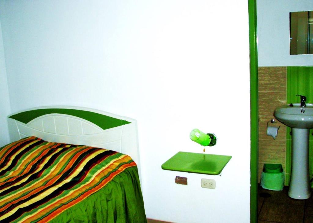 a bedroom with a bed and a sink in it at Hospedaje Harjeny in Trujillo