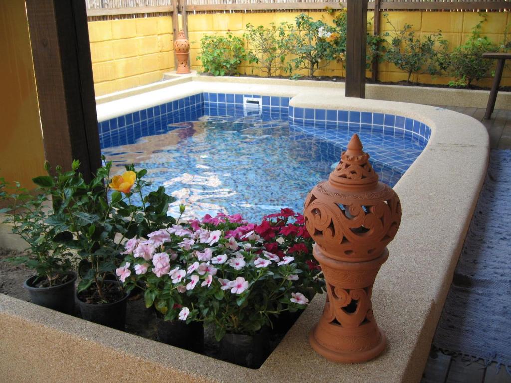 a small swimming pool with flowers in a planter at BTC Hua Hin Home managed by BTC Boutique Resort in Hua Hin
