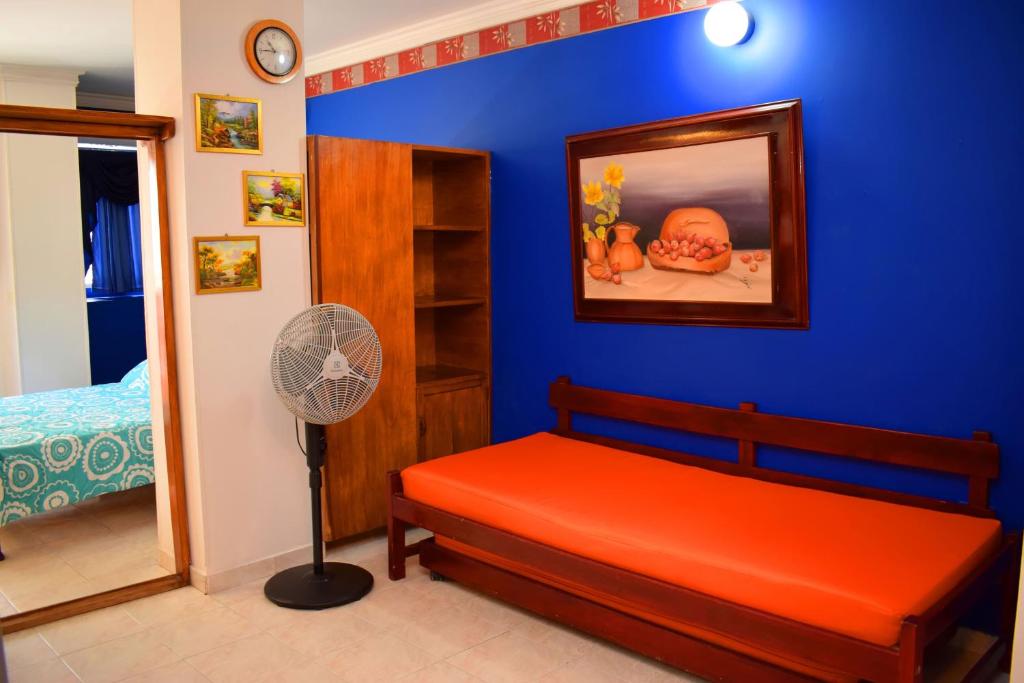 a bedroom with a red bed and a blue wall at APARTAMENTO EDIFICIO LOS LAURELES in Santa Marta
