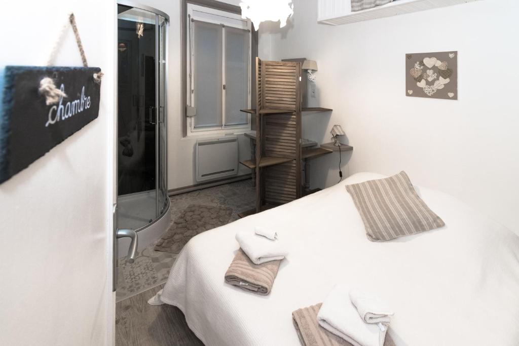 um quarto branco com uma cama com toalhas em Le Galet de Mers em Mers-les-Bains
